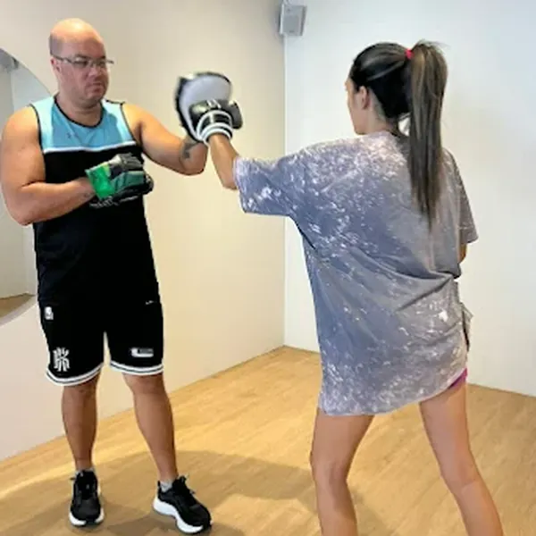 Treino de boxe com instrutor e aluna na Audaz Clínica Integrada
